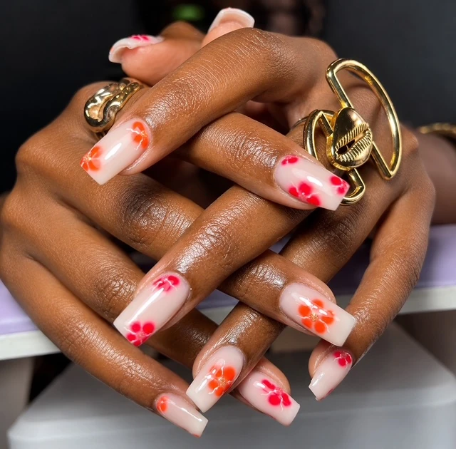 Ongles carrés longs, base laiteuse et fleurs rouges et orange