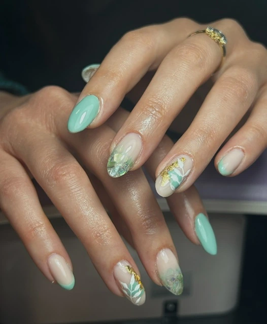 Ongles amande vert menthe et nude, décorés de feuilles dorées
