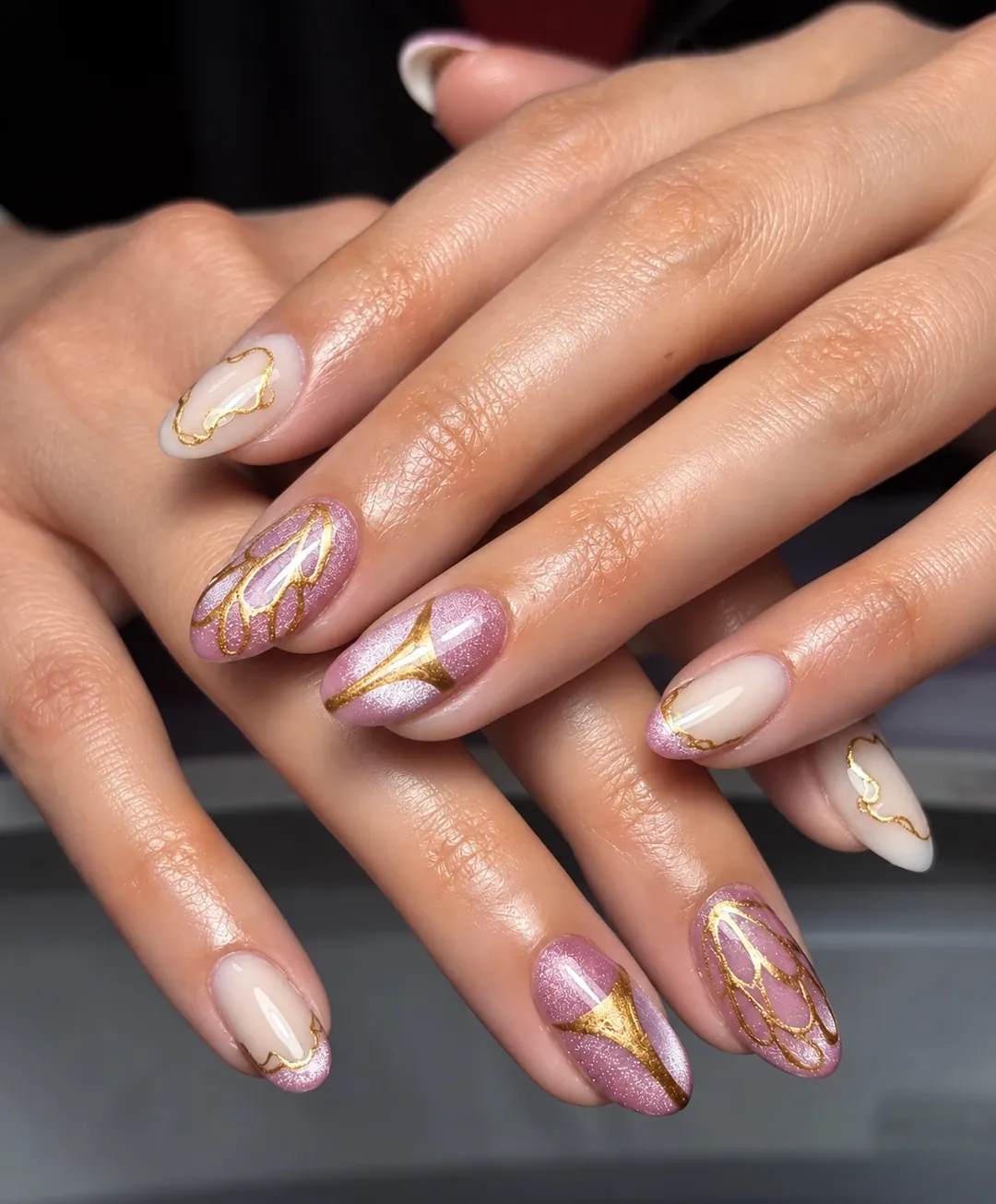Ongles amande rose pailleté et nude, traversés de lignes dorées